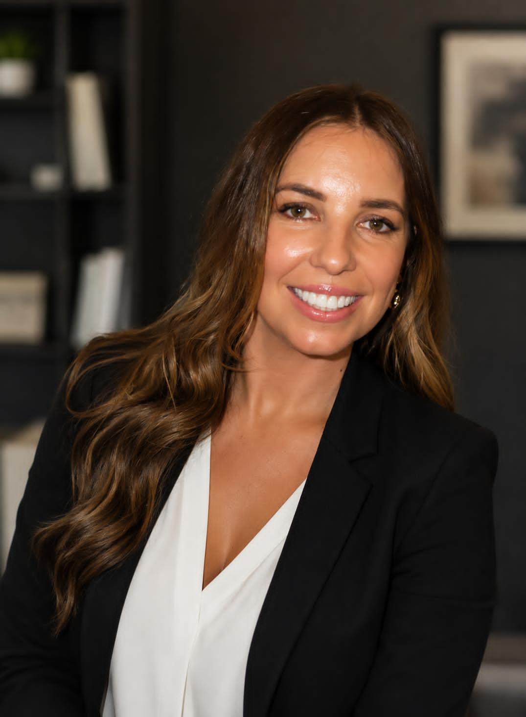 Andrea McGuill smiling in a black blazer and white blouse